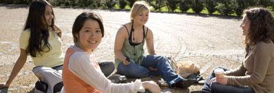 Students sitting on the ground in a group outside