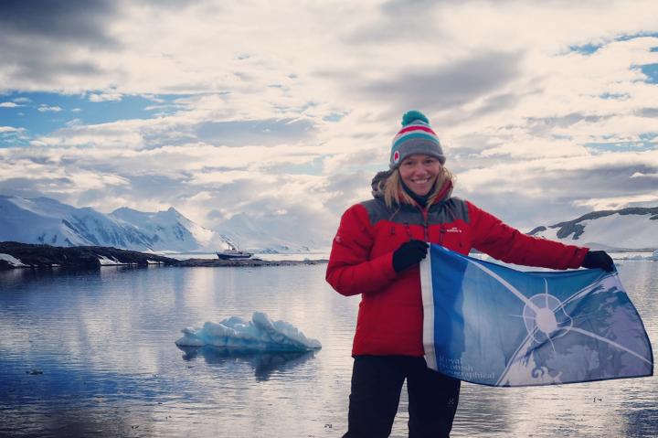 Beth Christie with flag in Antarctica