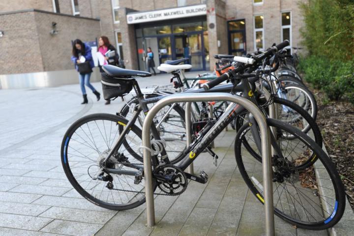 Bikes tied to bike racks outside a university building.