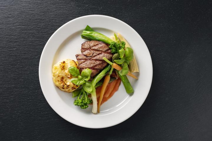 A plate of meat with a small portion of meat and lots of vegetables