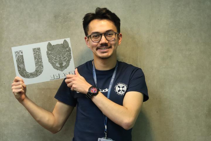 Abdul Hakim Norazman, Makerspace Technician, holding a laser cut design