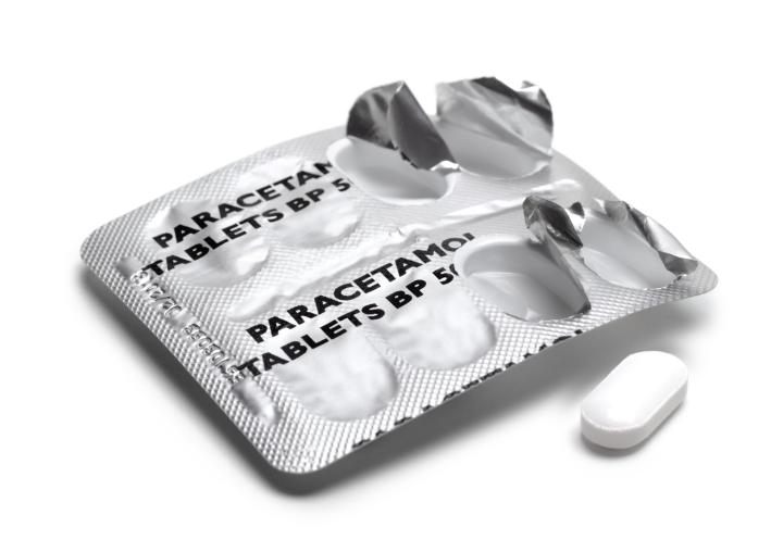 A photograph of a paracetamol aluminium strip with a pill popped out of it