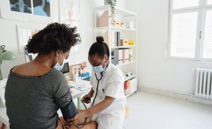 Female doctor checking the patient's blood pressure
