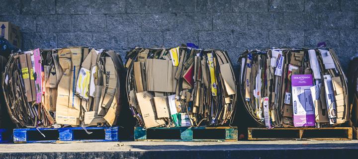 Phot of 3 pallets, each with a large package of cardboard on top.