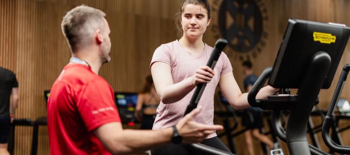 Member of staff helping gym member with new kit