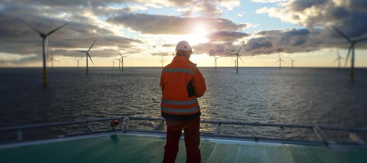 Offshore worker looking at wind turbines