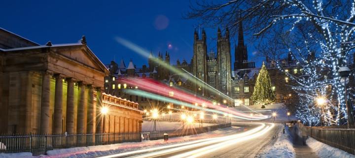 Light trails from traffic moving down The Mound in central Edinburgh, Scotland during December