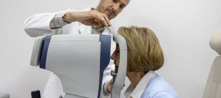 Male doctor performs eye exam on a female patient using OCT scanner