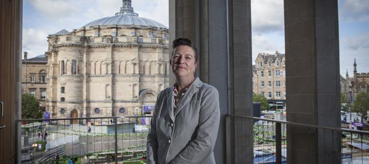 Gwen Orr stands with McEwan Hall and Bristo Square in the background