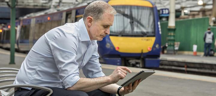 Man using tablet at train station