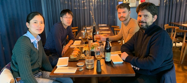 Group photo of lab members sat around a restaurant table