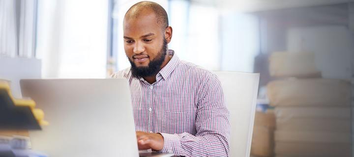 Photo of a male working on a laptop