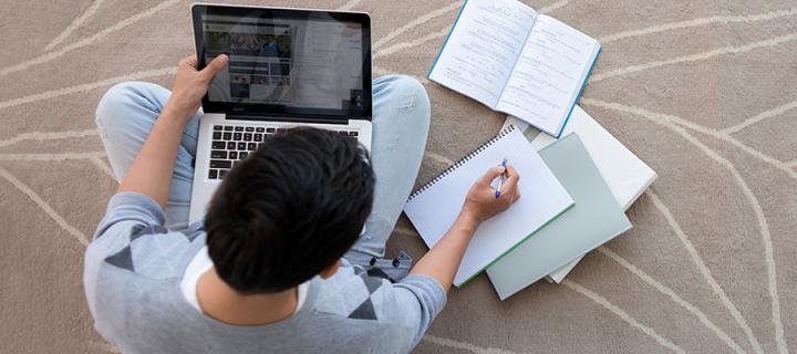 Photo of a male student studying on a laptop