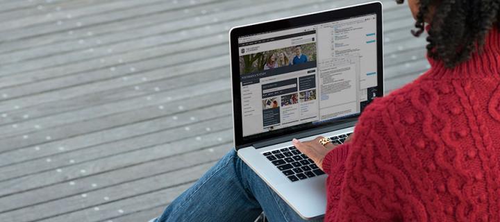 Photo of a female student browsing the University website on a laptop