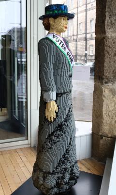 Image a life sized lego brick statue of a suffragette