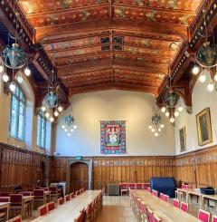Large room with tall ceilings, bright and airy with tables and chairs