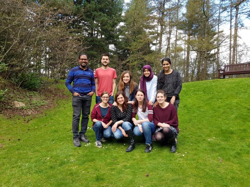 Group photo outside on grass beside trees