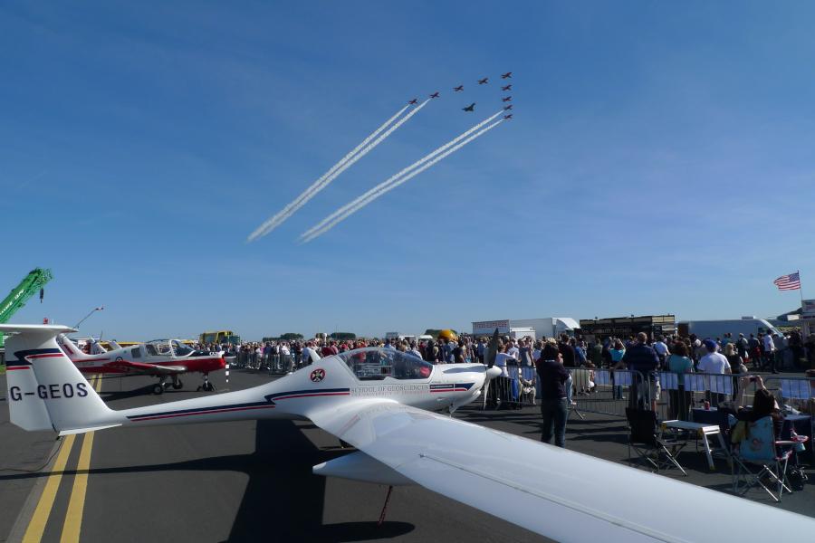 Dimona aircraft on ground display at an airshow with red arrows above