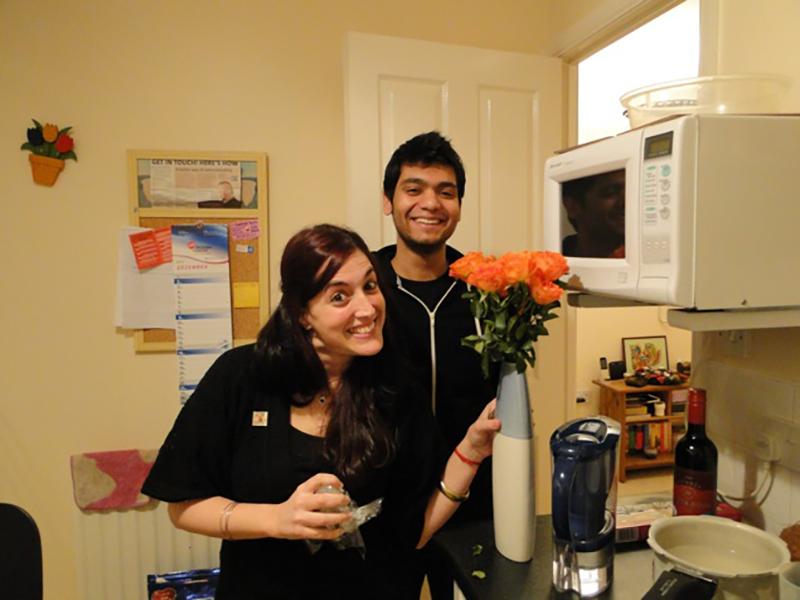 Two lab members in a kitchen show off a vase of flowers