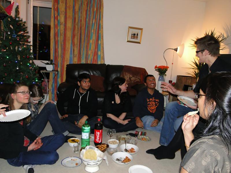 Lab group members sit around a living room decorated for Christmas