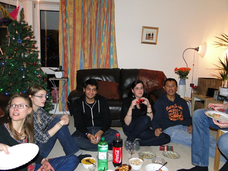 Lab group members stand around a living room decorated for Christmas