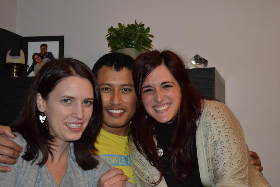Three lab group members pose for group photo in a house with shelving behind them
