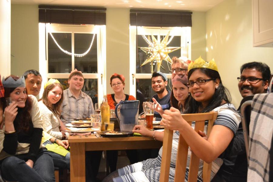 Lab group members sit around a dining table in a room decorated for Christmas
