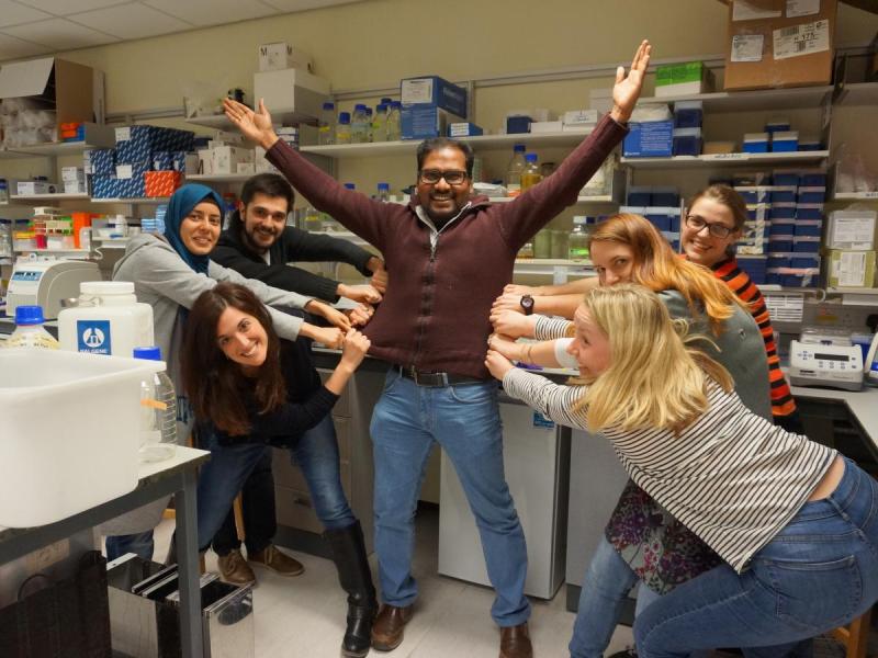 Lab group members pull JP's jumper in different directions