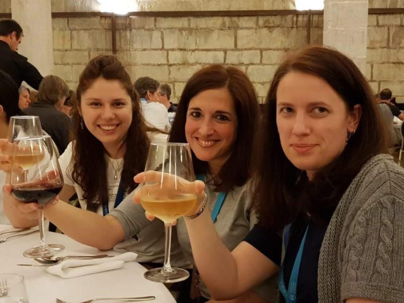 Three lab group members sit a table raising a toast