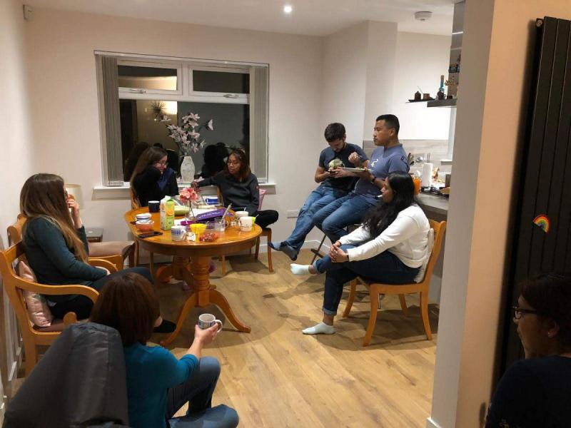 Lab group members seated in chairs around a kitchen table