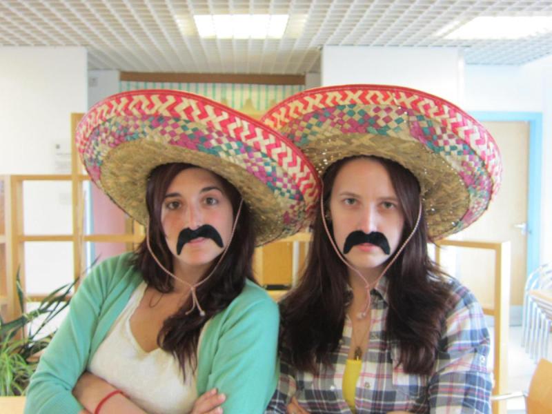 Two lab group members in somreros with large fake mustaches