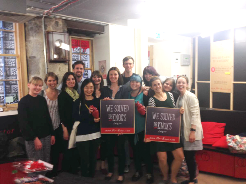 Photo of the group at Surgeon's Hall with a sign saying "we solved Dr Knox's enigma"