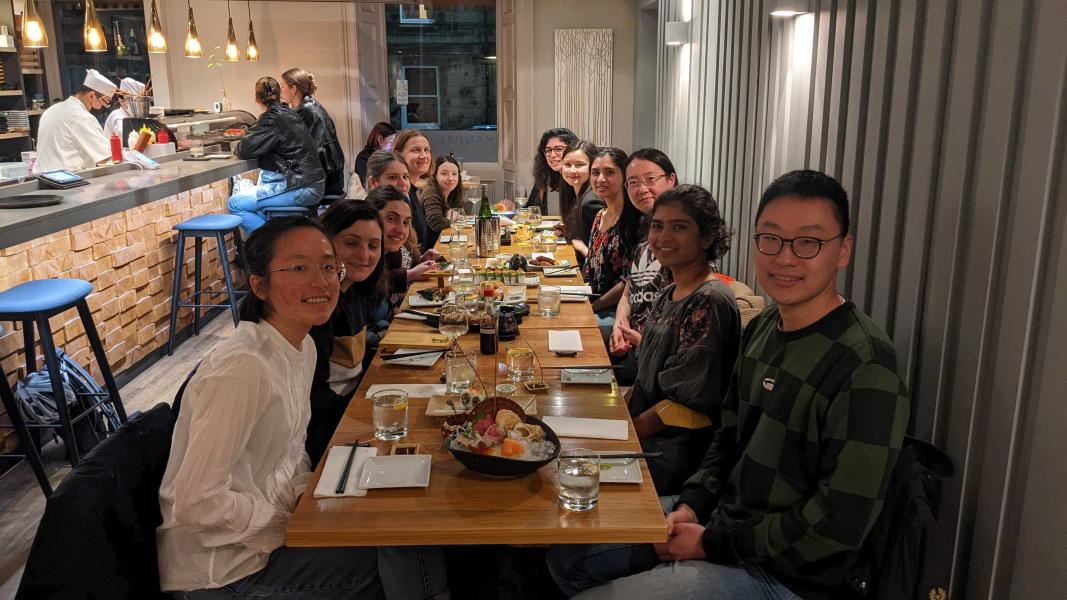 Group photo of lab members seated at a long table in a restaurant