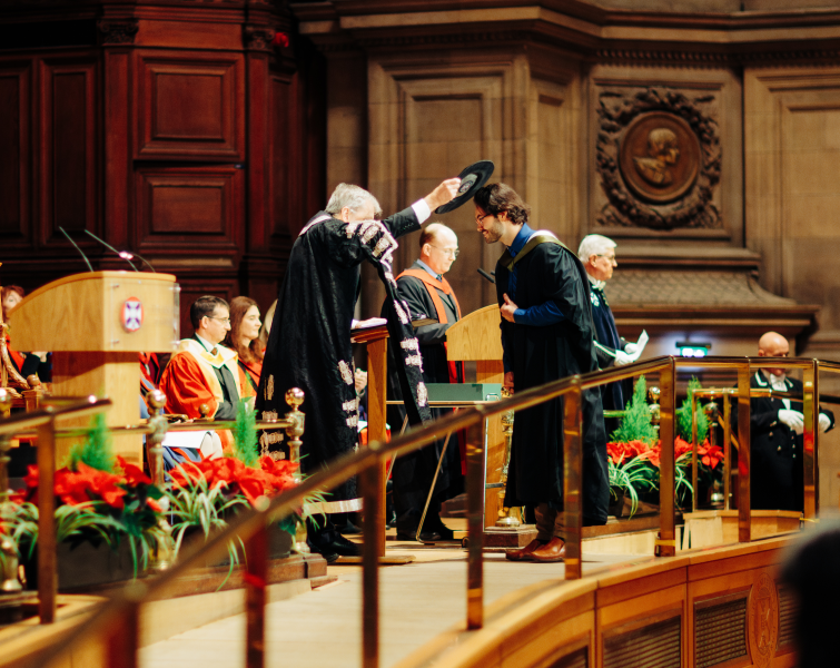 Principal Peter Matheson doffing a graduate with Geneva Bonnet