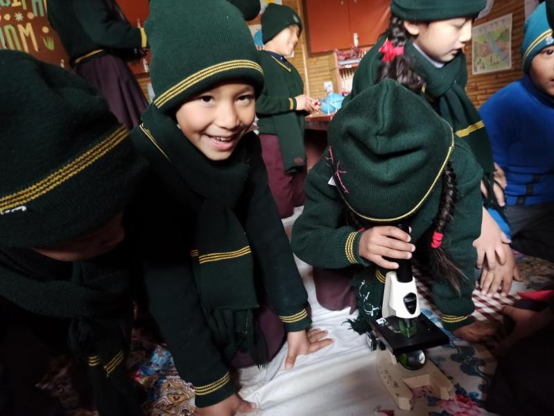 Children in school uniforms taking part in a workshop